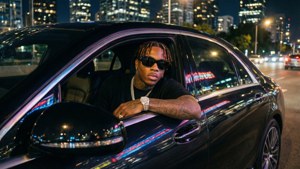 Lil Durk 喺豪華汽車入面，背景係城市夜景燈光。
