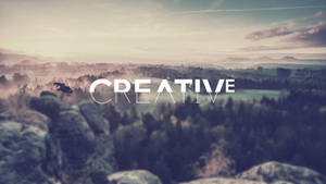 黎明時分霧氣瀰漫的山景，帶有「CREATIVE」文字覆蓋。