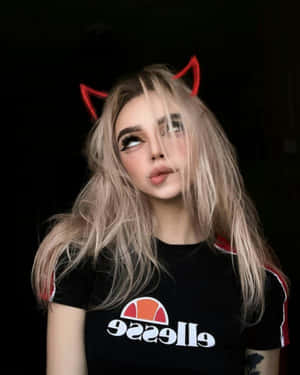 金髮紅惡魔角的年輕女性身穿黑色Ellesse T恤。