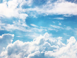 明亮的藍天，蓬鬆的白雲在地平線上飄移。 — 藍天 壁紙