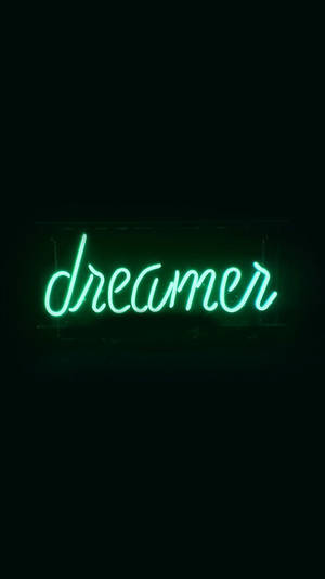 一個發光的綠色霓虹燈牌，上面寫著 dreamer，背景為黑色。