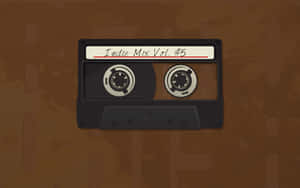 一盒標有Indie Mix Vol 5的黑色卡式錄音帶，置於棕色紋理背景上。