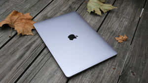 銀色 MacBook 在木甲板上與秋葉 — Mac GIF 壁紙