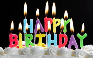 生日蛋糕上點燃了色彩繽紛的字母蠟燭，拼出 happy birthday。 — 蠟燭 GIF 壁紙