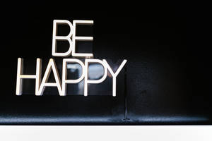 黑色紋理表面上的金屬「BE HAPPY」字母 — 開心 GIF 壁紙