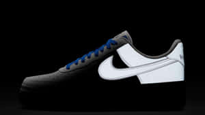 一雙黑白Nike Air Force 1運動鞋，藍色鞋帶，黑色背景。