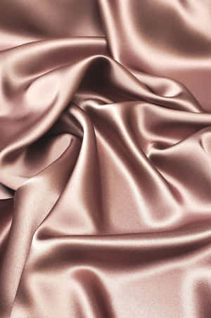 玫瑰金緞面布料的特寫，帶有柔軟的皺褶和閃爍的高光。