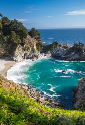 在清澈的藍天下，碧綠的海水和岩石峭壁的海岸小海灣。 — 秋天 壁紙