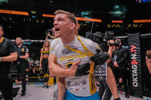 MMA 選手被抬出八角籠，與隊友慶祝勝利。