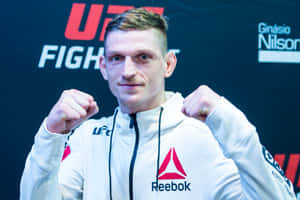 身穿白色Reebok連帽衫的UFC拳手舉起拳頭擺姿勢。