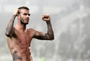 David Beckham在運動場上展示他紋身的手臂。