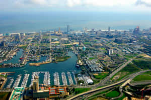 從上方觀看的沿海城市景觀，包含碼頭和現代建築。 — 紐約市 壁紙