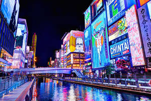 夜間東京運河，發光的霓虹燈倒映在水中。 — 火影忍者海報 壁紙