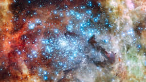 充滿閃爍藍色星星和旋轉紅橙色氣體雲的鮮豔宇宙星雲。 — 太空 壁紙
