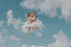 兩個天使在天空中的雲朵上以充滿愛意的擁抱漂浮。
