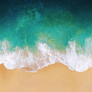 碧綠色的海浪從上方滾向金色沙灘海岸。