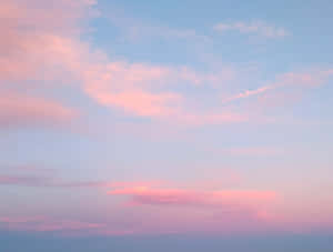寧靜暮色天空中的粉彩粉紅和藍色雲朵。
