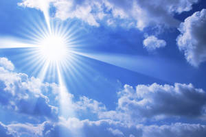 太陽在藍天中穿過白雲明亮地照耀。