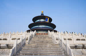 藍色屋頂和金色頂部的寺廟，在晴朗的天空下位於石階上。 — 廟宇 壁紙