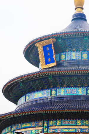 淡色天空下，天壇屋頂帶有藍色瓦片和金色點綴 — 建築 壁紙