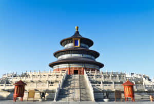 圓形中國寺廟，藍色屋頂和紅色柱子，位於石台上，天空晴朗。 — 中國 壁紙