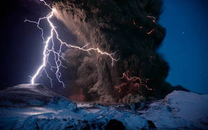 夜間火山爆發，閃電照亮火山灰雲和積雪。 — 天氣 壁紙