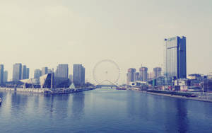 城市天際線，河流和摩天輪在朦朧的天空下