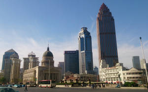 晴朗藍天下嘅城市景觀，有歷史同現代建築，仲有人同車輛。 — 唐人街 GIF 壁紙