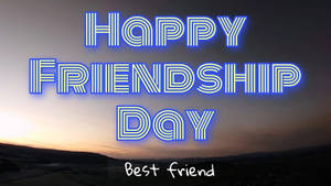 霓虹燈牌寫著 'Happy Friendship Day' 在日落景觀之上。