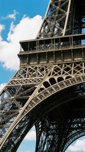 艾菲爾鐵塔金屬結構特寫，藍天白雲下