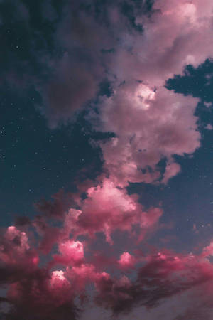 粉紅色雲朵在星空夜空中漂浮，帶有藍綠色調和發光的星星。