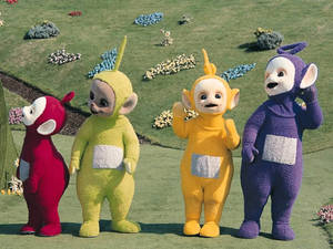 四個天線得得B角色站在有花壇的草地上。