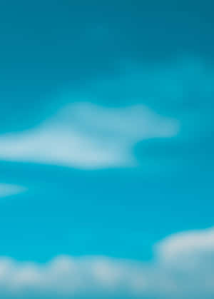 充滿活力的青綠色天空，柔和模糊的雲朵平靜地飄移。 — 藍天 壁紙