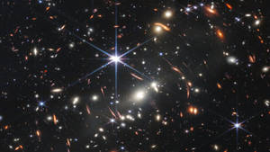 深空視圖，顯示星系和恆星，帶有鏡頭光暈。