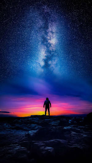 人站在岩石上，星空下，銀河可見