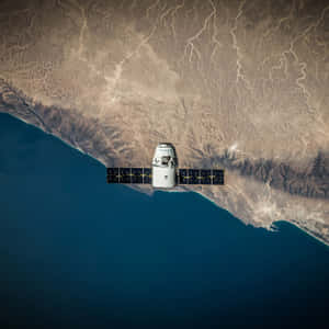 沙漠海岸上空的太陽能板衛星 — 太空 壁紙