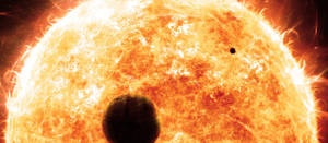 兩顆行星在一顆帶有太陽耀斑的熾熱太陽前經過。