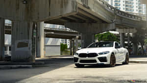 白色BMW M8 Coupe配金色輪圈，停泊在城市天橋下。