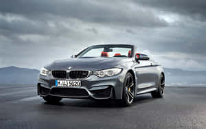 銀色BMW M4開篷車，紅色座椅，濕滑道路，多雲天空。