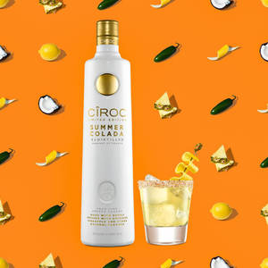 Ciroc Summer Colada伏特加酒瓶和雞尾酒，搭配熱帶水果裝飾，背景為橙色。