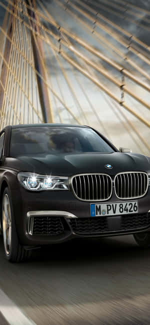 黑色BMW 7系在現代懸索橋上疾馳。 — Infinix Note 壁紙