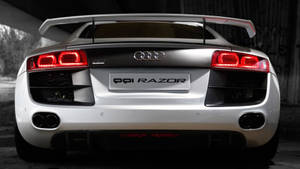 銀色奧迪R8跑車，帶有紅色尾燈，停在塗鴉覆蓋的天橋下。 — Audi R8 GIF 壁紙