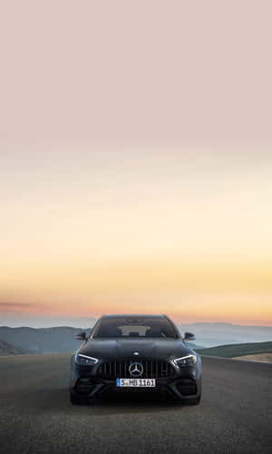 黑色Mercedes-AMG跑車在山路夕陽下 — Infinix Xpad 20 Pro 壁紙