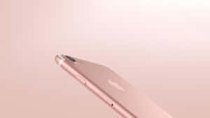 玫瑰金色iPhone在柔和粉紅色背景上帶有Apple標誌