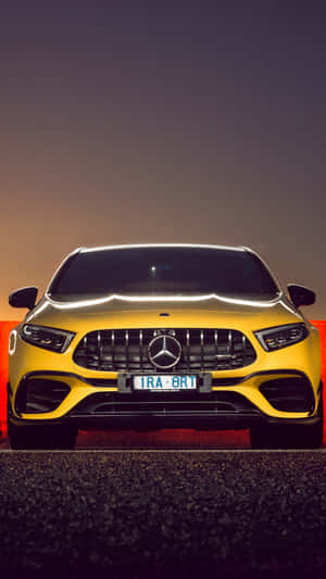 夜間黃色Mercedes-AMG跑車，帶有發光的頭燈和水箱護罩。