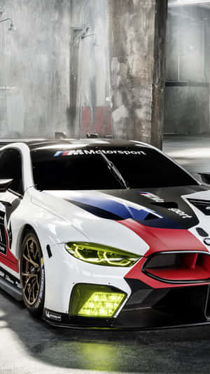 BMW M8 GTLM賽車在混凝土車庫中，頭燈發光。