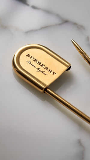 白色大理石背景上的金色 Burberry 鋼筆