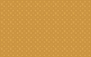 芥末黃色背景上的金色 Louis Vuitton 字母組合圖案。