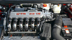 銀色 V6 汽車引擎的特寫，帶有紅色字樣和鍍鉻部件。