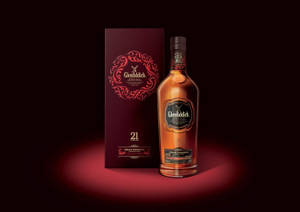 Glenfiddich 21 年威士忌酒瓶和盒子在紅光中照亮。